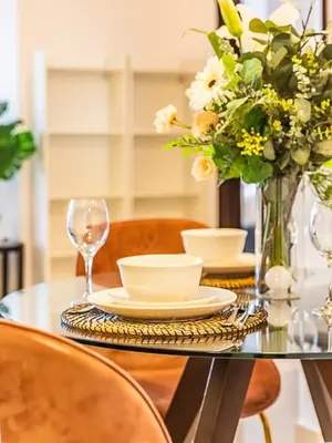 a glass table with a vase of flowers and a vase of glasses at Luxury Modern 1BR-Concorde Tower 1-JLT in Dubai