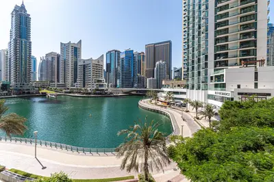 a river in the middle of a city with tall buildings at Bright 1-Bedroom with Marina Infinity Pool in Dubai