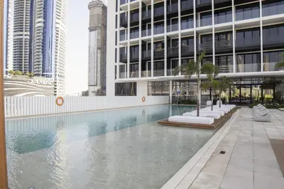 a swimming pool in front of a building with tall buildings at Modern Studio, Burj Views - Business Travelers in Dubai