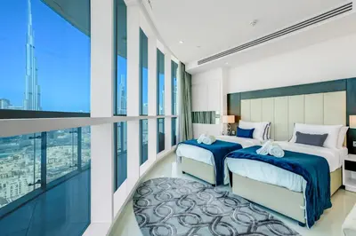 a bedroom with two beds and a large window at 2 Bedrooms with Iconic Burj Khalifa Views Stay in Dubai