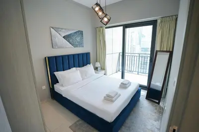 a bedroom with a large bed and a balcony at Luxurious Pool View 1BHK, Zada Tower in Dubai