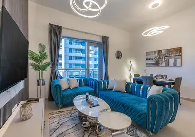 a living room with a blue couch and a tv at Luxurious one bedroom Apartment with Burj Khalifa View in Dubai