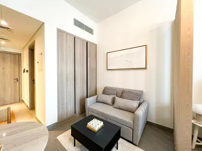 a living room with a couch and a table at Modern Studio in JVC - Pool, Gym & BBQ Access in Dubai