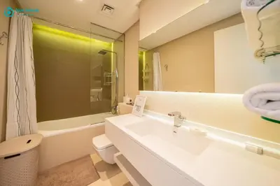 a bathroom with a sink and a toilet and a mirror at Blue Breeze - Modern Apt with Partial Marina Views & Balcony in Dubai