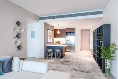 a living room with a white couch and a kitchen at Luxury 2 Bedroom Apartment with Breathtaking Dubai in Dubai