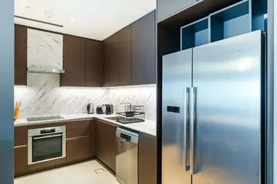 a kitchen with a stainless steel refrigerator at Luxury 2 Bedroom Apartment with Breathtaking Dubai in Dubai