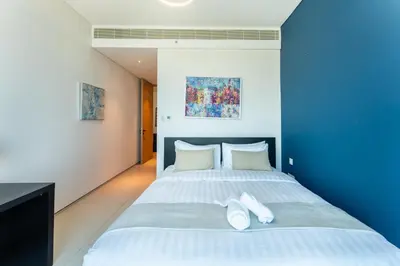 a bedroom with a large bed with blue walls at Luxury 2 Bedroom Apartment with Breathtaking Dubai in Dubai