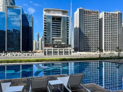 a swimming pool with chairs and a city skyline at japanDXB Burj Khalifa view - 4min Dubai Mall in Dubai