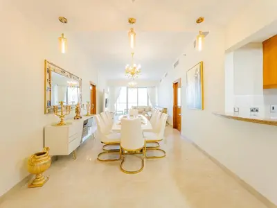 a dining room with a table and white chairs at SettlerHomes - FIRST CLASS JBR Stay On High-Floor in Dubai