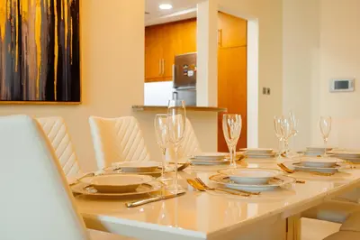 a dining room table with plates and glasses on it at SettlerHomes - FIRST CLASS JBR Stay On High-Floor in Dubai
