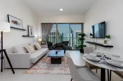 a living room with a white couch and a table at Near Burj Khalifa - 1BR Apartment in Grande Residence, Downtown - Allsopp & Allsopp in Dubai