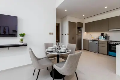 a kitchen and dining room with a table and chairs at Near Burj Khalifa - 1BR Apartment in Grande Residence, Downtown - Allsopp & Allsopp in Dubai