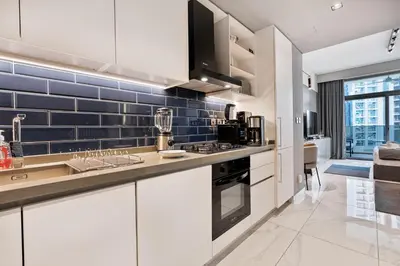 a kitchen with white cabinets and blue tiles at Upmarket Studio in Business Bay with a Gym and Pool in Dubai