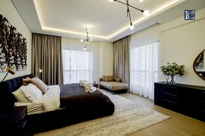 a bedroom with a large bed and a living room at Luxury Escapes - Three-Bedroom Apartment with Lake View in Dubai