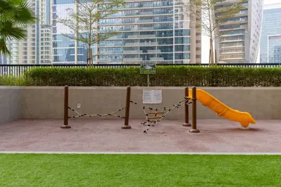 a playground with a slide in a park at Waves - Modern Apt with Balcony & Canal View in Business Bay in Dubai