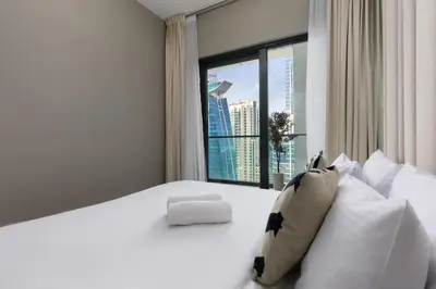 a bedroom with a white bed with a large window at Waves - Modern Apt with Balcony & Canal View in Business Bay in Dubai