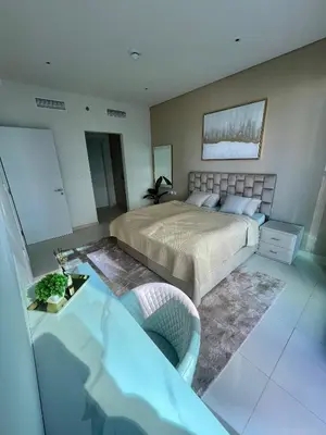 a bedroom with a bed and a table in it at Great one bedroom apartment with infinity pool in Dubai