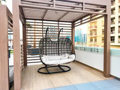 a chair sitting on top of a balcony at Stylish 1-Bedroom Retreat in Prime Gardens , Arjan in Dubai