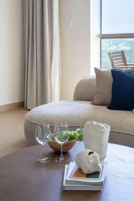 a table with two wine glasses and a bowl of grapes at Frank Porter - Zen Tower in Dubai