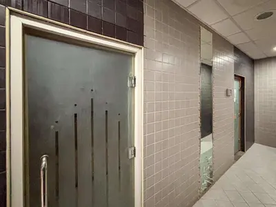 a door in a bathroom with a tile wall at Frank Porter - Zen Tower in Dubai