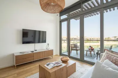a living room with a tv and large windows at Frank Porter - Palm Views East in Dubai