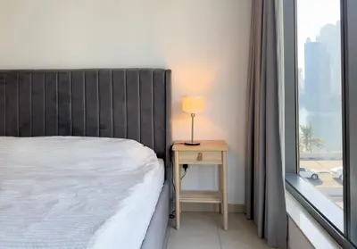 a bedroom with a bed and a table with a lamp at 2 bedroom luxury flat in Dubai Marina in Dubai