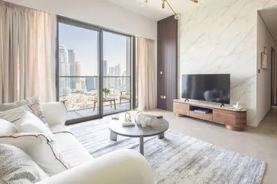 a living room with a white couch and a tv at Frank Porter - Grande Residence in Dubai