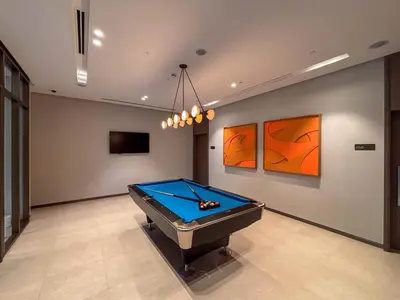 a pool table in a room with paintings on the wall at Frank Porter - Grande Residence in Dubai