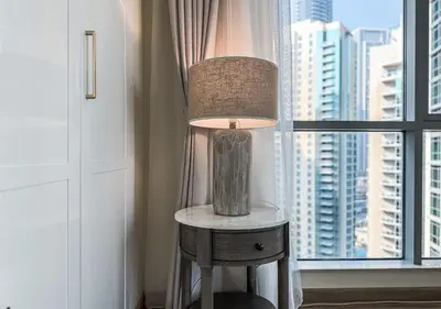 a lamp on a table in front of a window at DreamShoma-3BR Super Luxurious The Residence 5 Downtown in Dubai