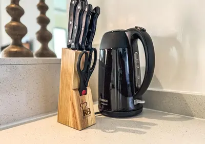 a knife block next to a black appliance on a counter at DreamShoma-3BR Super Luxurious The Residence 5 Downtown in Dubai