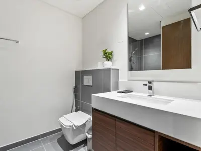 a bathroom with a sink and a toilet and a mirror at Serene 2BDR with Beach Scenery In Creek Edge- Creek Harbour in Dubai