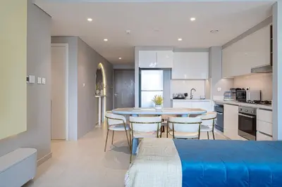 a kitchen and dining room with a table and chairs at Downtown Dreams Burj Khalifa View with Dubai Mall, Pool & Free Parking in Dubai