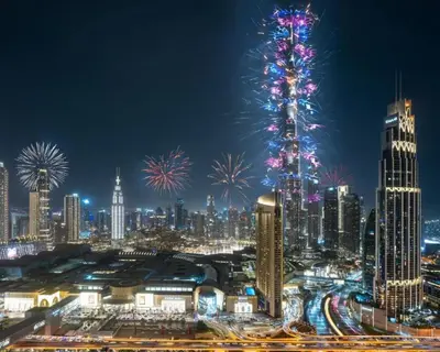a city skyline with fireworks and a christmas tree at Downtown Dreams Burj Khalifa View with Dubai Mall, Pool & Free Parking in Dubai