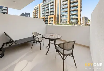 a patio with a table and chairs on a balcony at Azizi Riviera Studio with Chic Furnishing in Dubai