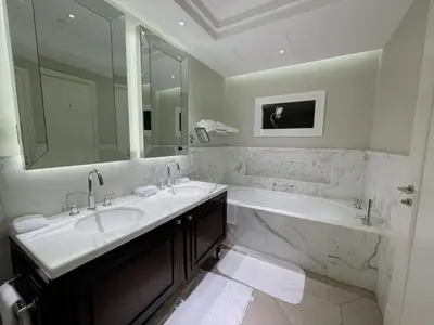 a bathroom with two sinks and a tub and a large mirror at Apt Dubai Downtown in Dubai