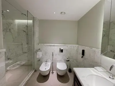 a bathroom with two sinks and a toilet and a shower at Apt Dubai Downtown in Dubai