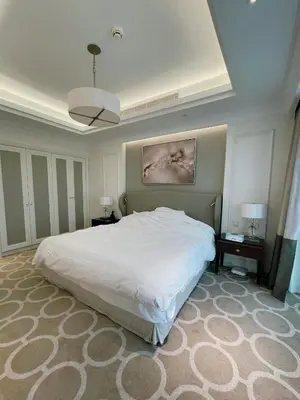 a bedroom with a large white bed and two lamps at Apt Dubai Downtown in Dubai