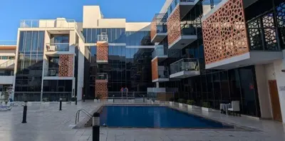 a large building with a swimming pool in front of it at Live a life of luxury in Dubai