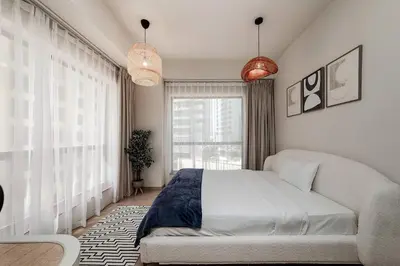 a bedroom with a bed and a large window at Cozy 1BR apartment in JBR in Dubai