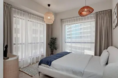 a bedroom with a bed and a large window at Cozy 1BR apartment in JBR in Dubai