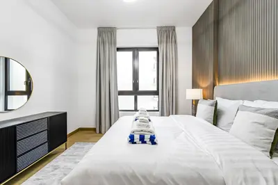 a bedroom with a large white bed with a mirror at Luxury lifestyle at La Sirene Port de la Mer Jumeirah 1 in Dubai