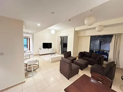 a living room with a couch and chairs and a tv at Spacious bedroom with easy access to the tram and beach, located near JBR Walk in Dubai