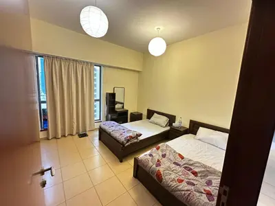 a hotel room with two beds and a window at Spacious bedroom with easy access to the tram and beach, located near JBR Walk in Dubai