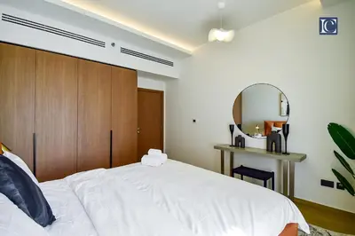 a bedroom with a white bed and a mirror at Luxury Escapes - Luxurious 2-Bedroom Apartment with Stunning Lake Views in JBR in Dubai