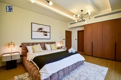 a bedroom with a large bed with a brown couch at Luxury Escapes - Luxurious 2-Bedroom Apartment with Stunning Lake Views in JBR in Dubai