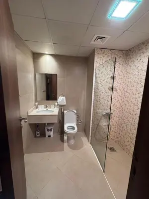 a bathroom with a toilet and a sink and a shower at Brand New Apartment IN JVC in Dubai