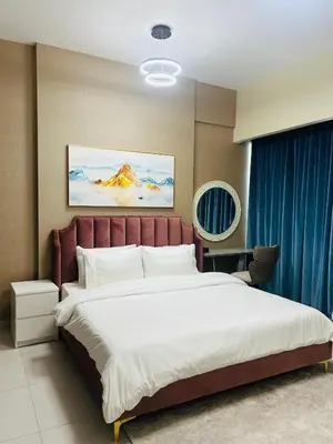 a bedroom with a large bed and a blue curtain at MontRose Residence Tower A in Dubai