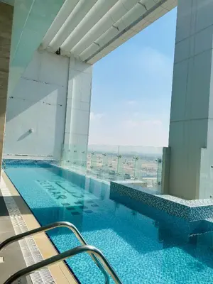 a large swimming pool in a building with a view at MontRose Residence Tower A in Dubai