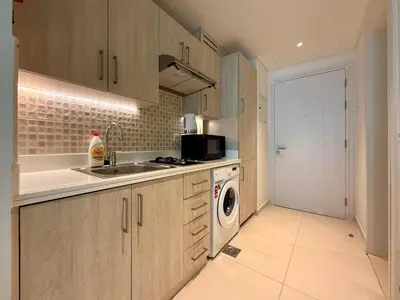 a kitchen with a sink and a washing machine at Studio Apartment in Seven Palm with Beach Access in Dubai