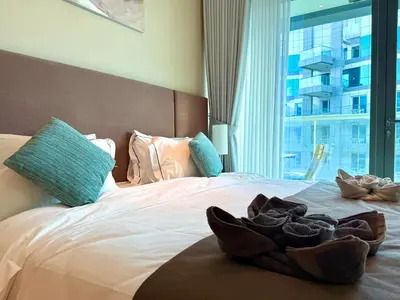 a pile of shoes sitting on a bed with a window at Studio Apartment in Seven Palm with Beach Access in Dubai
